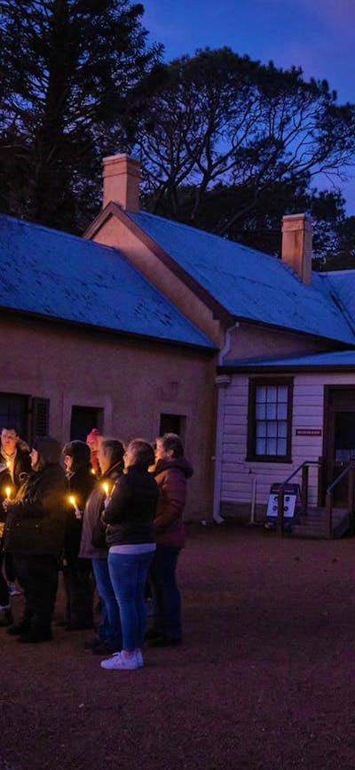 Group attending Stories at Sunset holding lanterns in the Lanyon Homestead courtyard