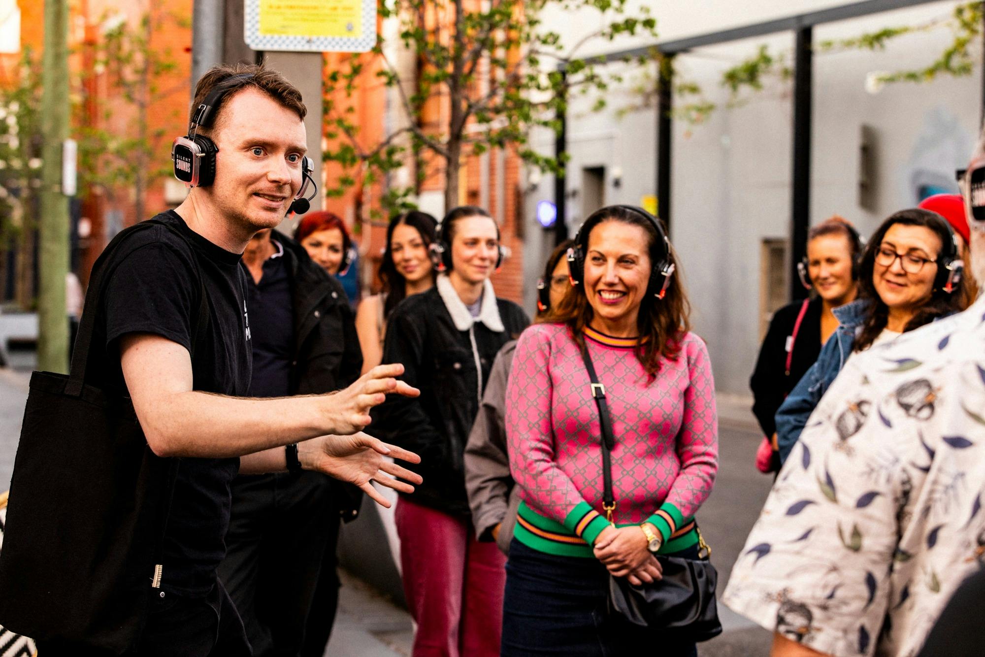 Man in black t-shirt talking to an audience with a terrified look on his face