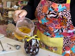 A workshop participant pouring wax into candle jar