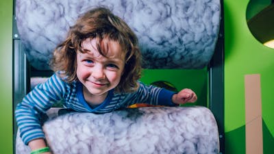 Photo of a child climbing through the sheeps pen