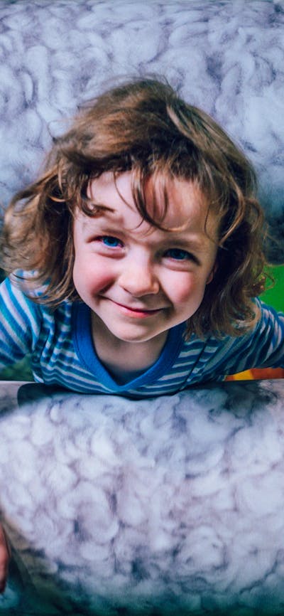 Photo of a child climbing through the sheeps pen