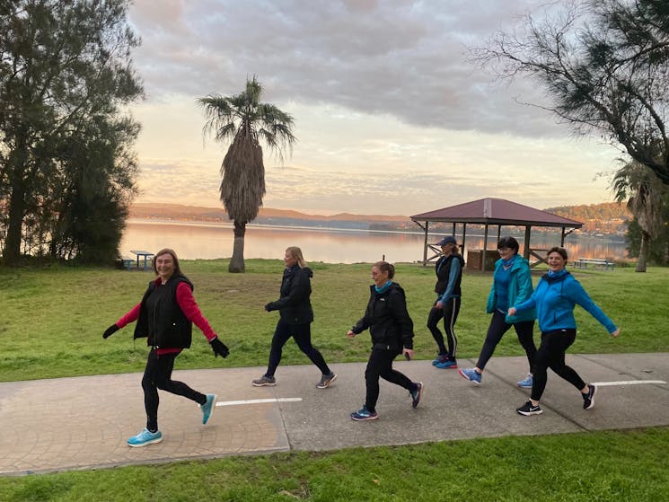 Six women walking at a fast pace along the Esplanade at Warners Bay NSW