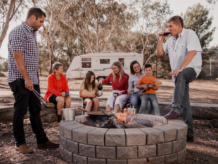 Family and friend sitting around fire pit