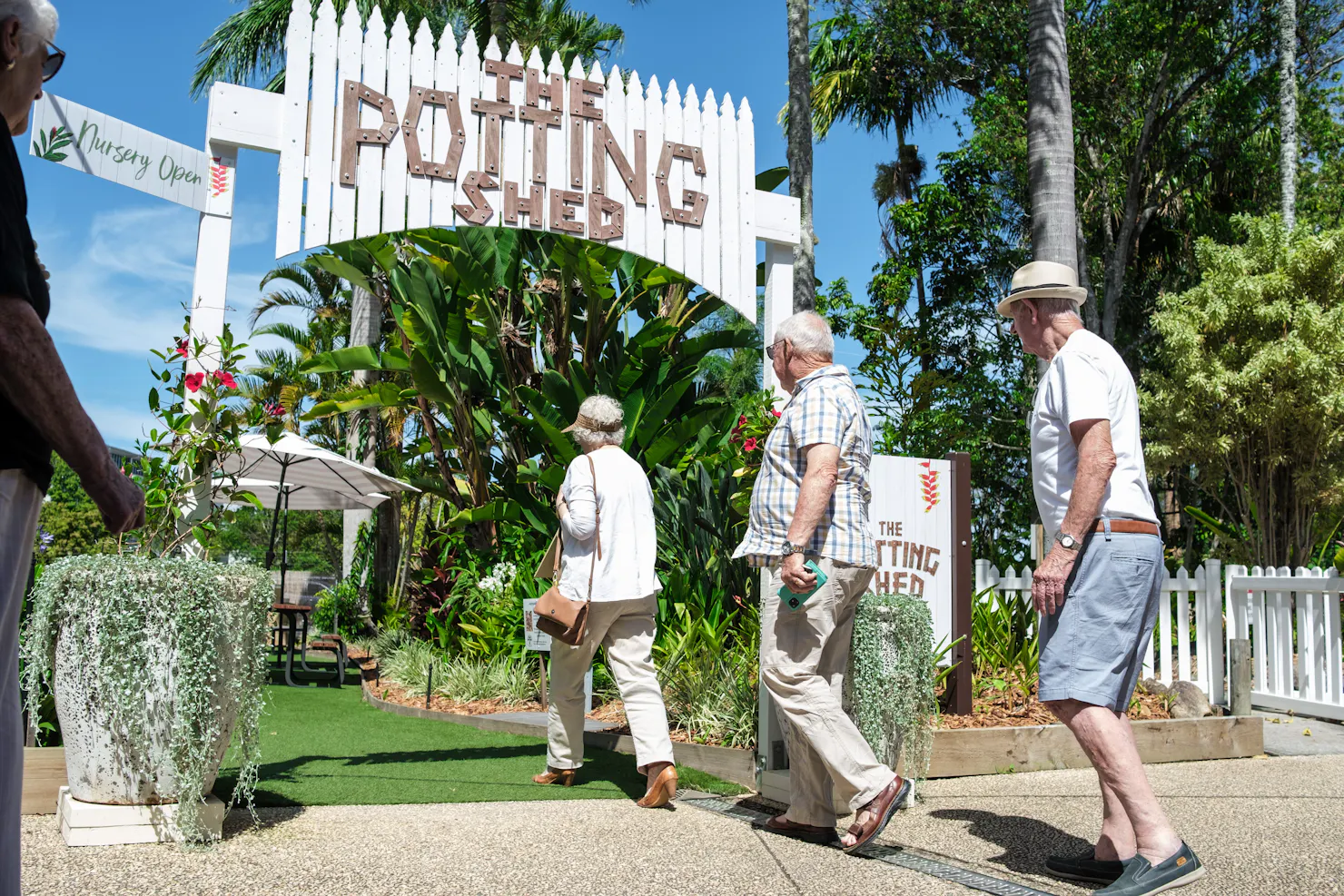 Three people strolling into The Potting Shed