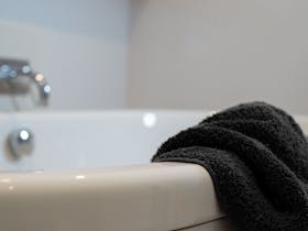 Freestanding bath with towel draped over edge