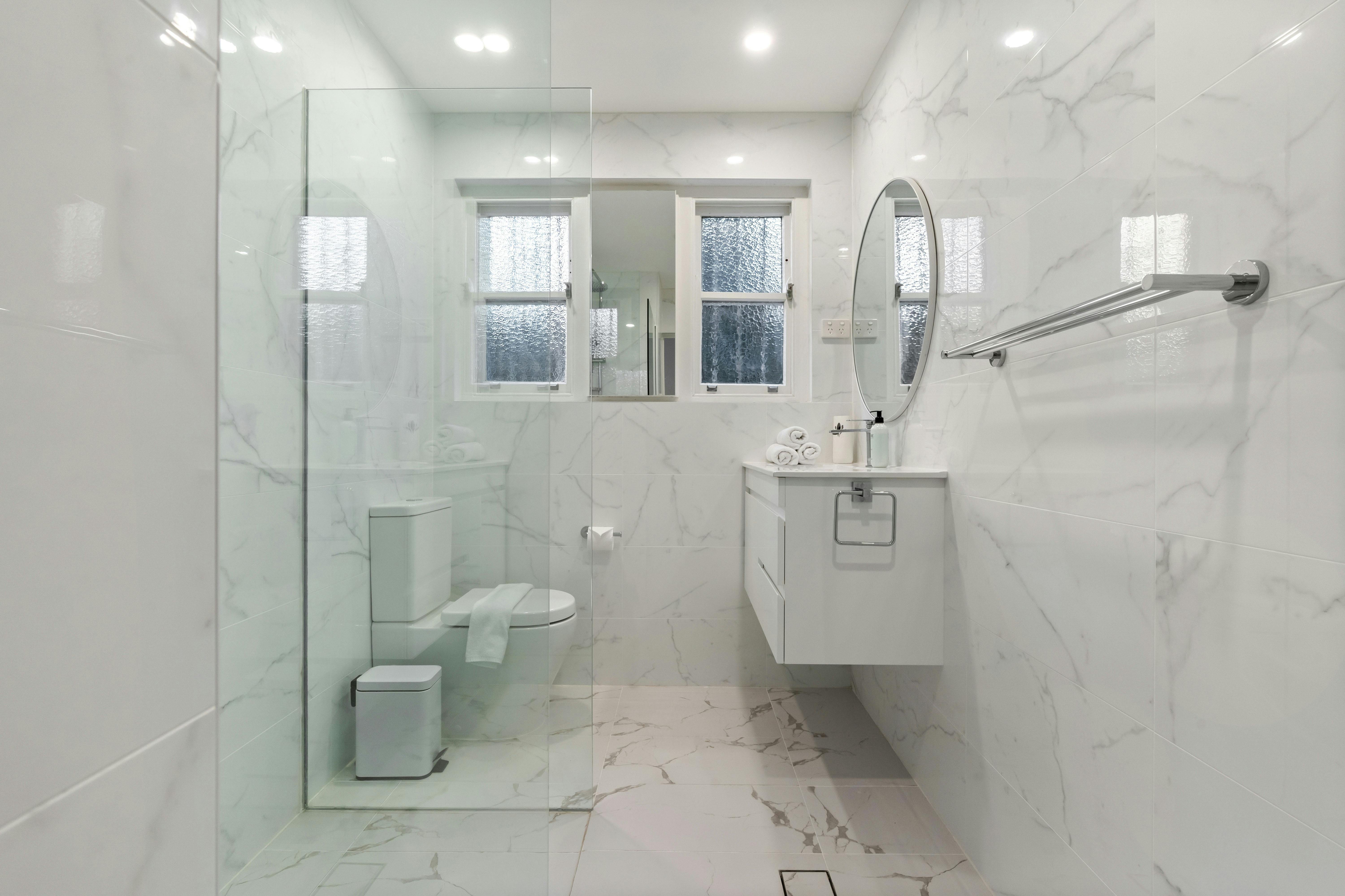 現代寬敞的浴室配有步入式淋浴間和大理石瓷磚。