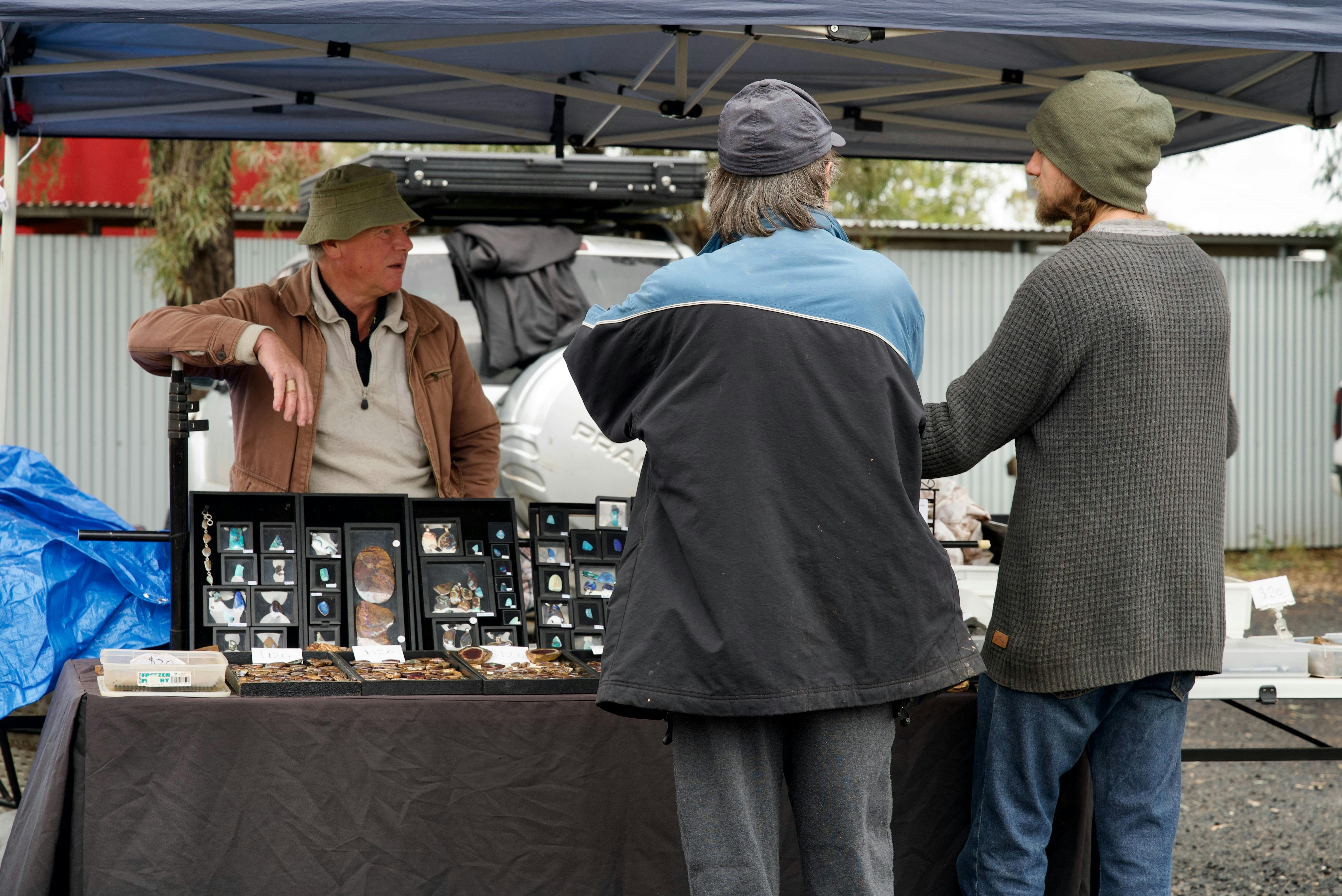 A candid shot of an Opal stallholder talking to his customers