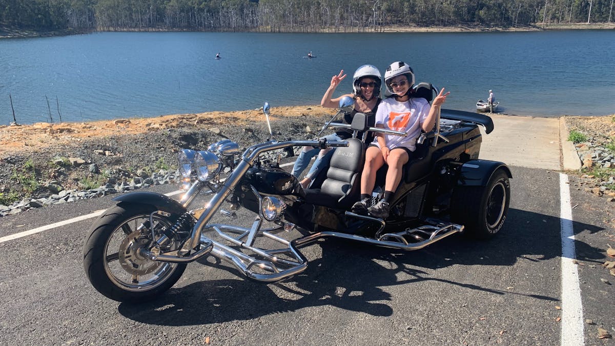 Image shows a boom mustang trike parked near the waterfront of Hinze Dam.