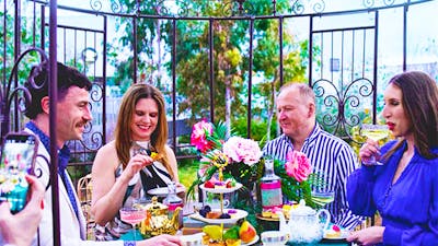 Guests enjoy gin cocktail high tea beneath a canopy at The Underground Gin Garden.