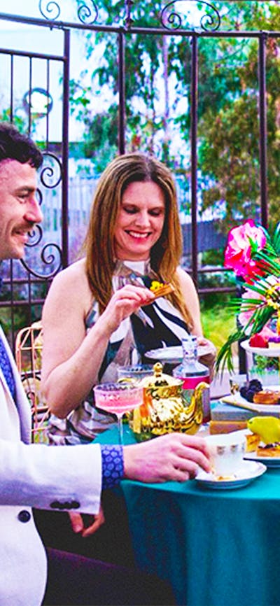 Guests enjoy gin cocktail high tea beneath a canopy at The Underground Gin Garden.