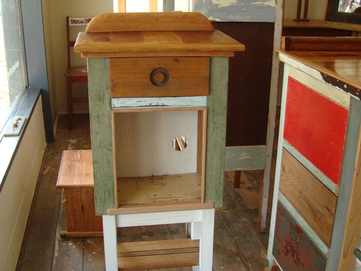 One-door-one-drawer cupboard made from an old bee box, on legs