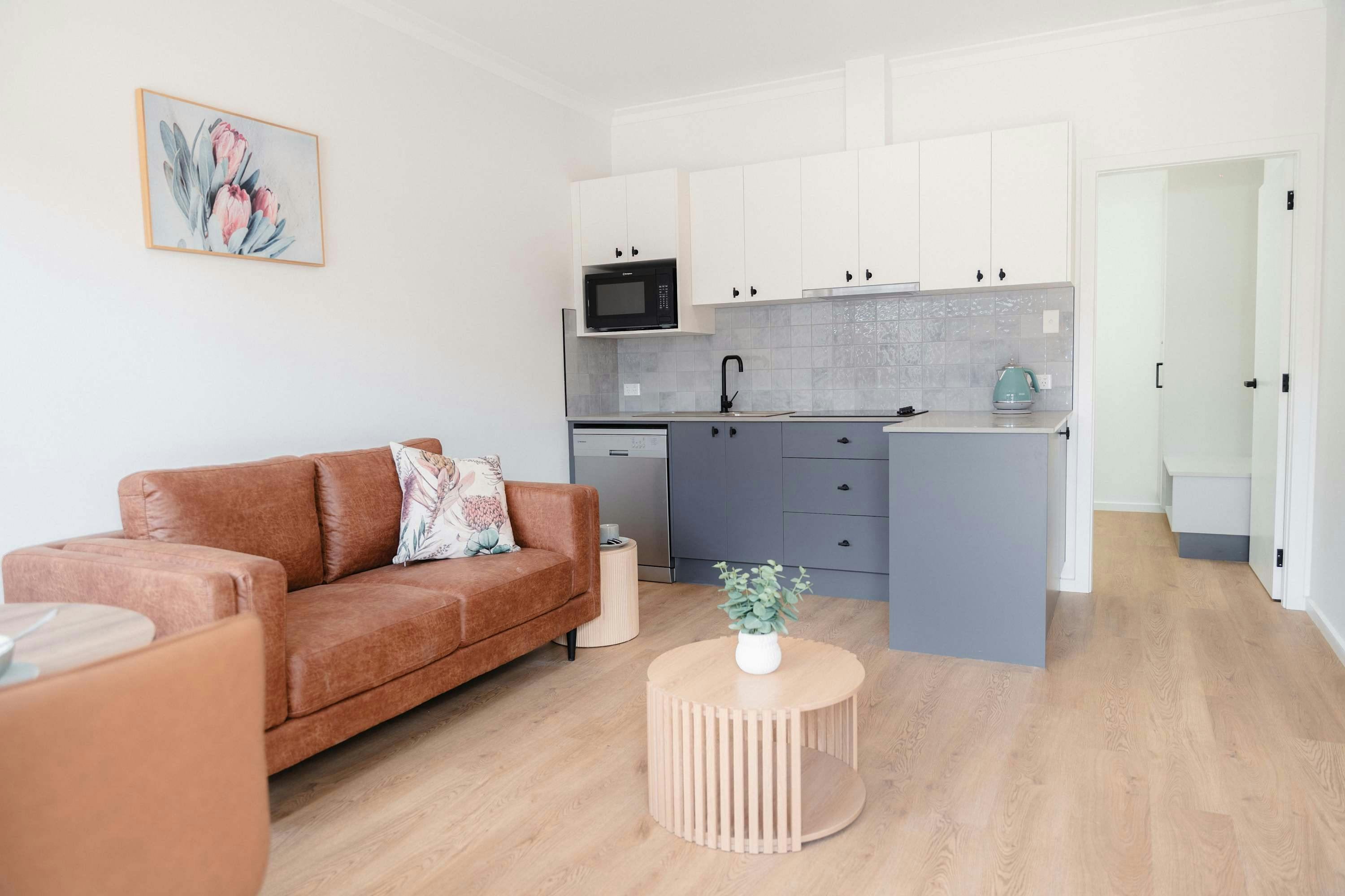 Blue kitchen cabinets, white upper cabinets, floral wall art