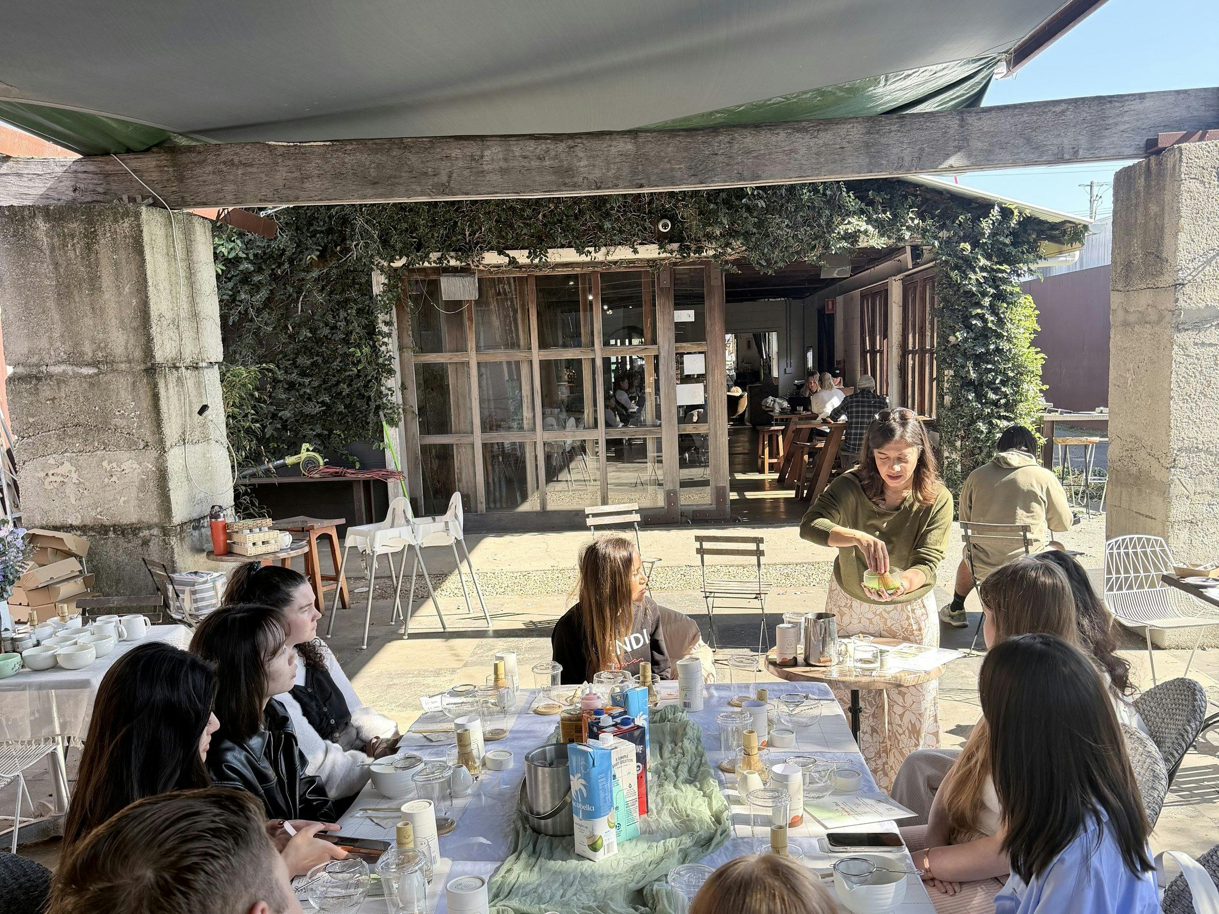 Group of guests at a long table during a NOA Matcha workshop