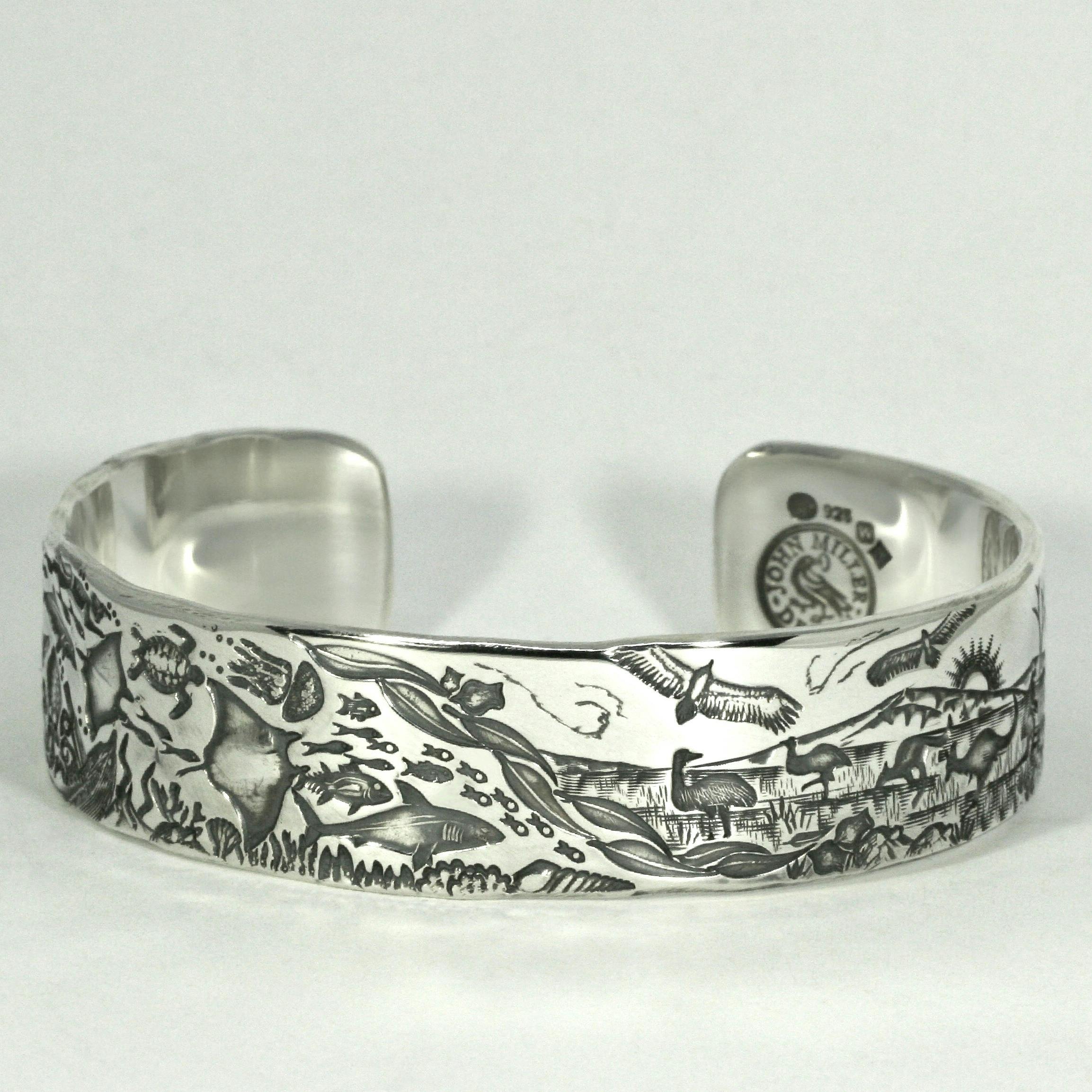 A handcrafted sterling silver cuff with an Ocean to Outback story scene by John Miller Design