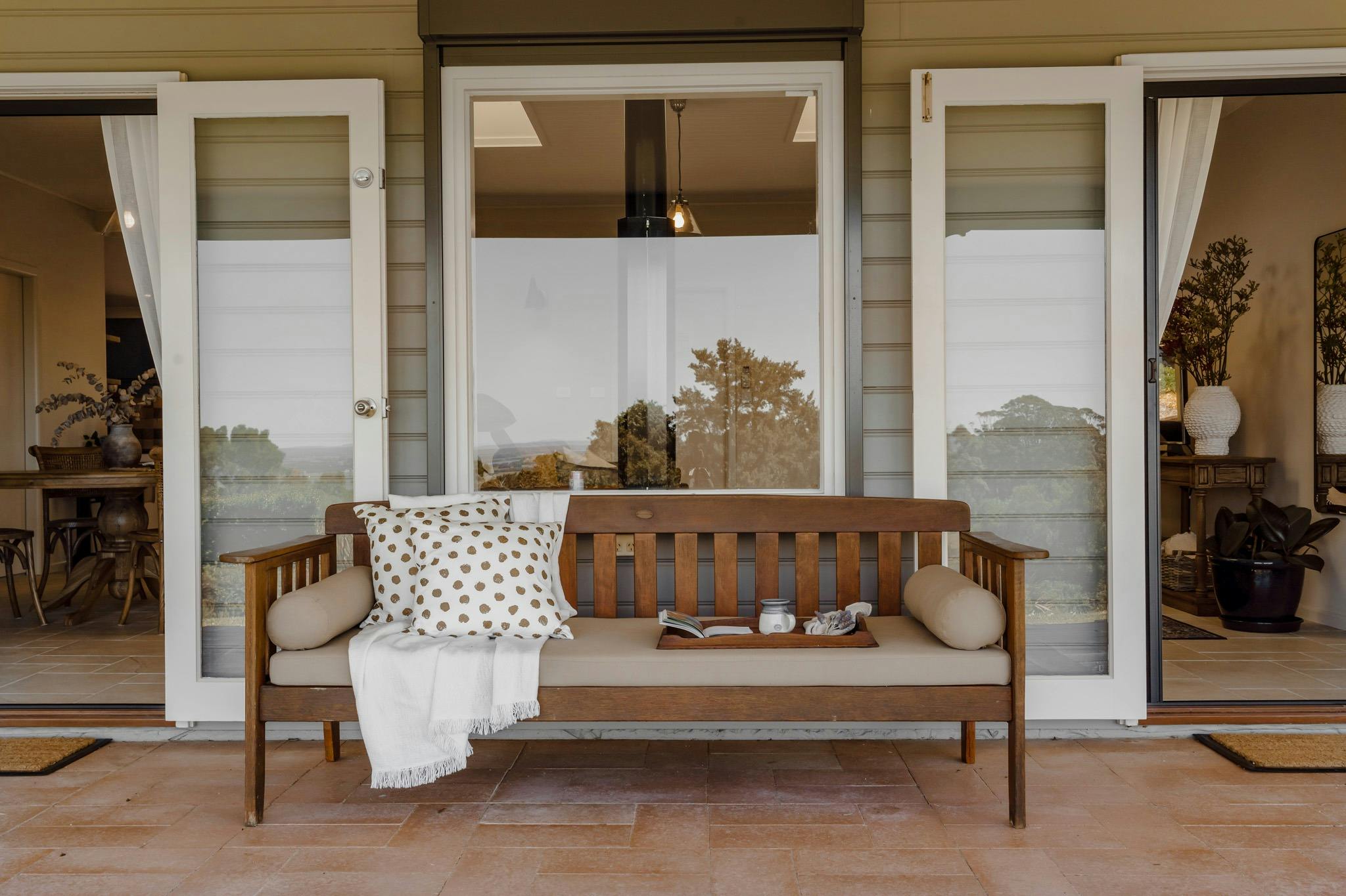 wooden daybed with cushions and throw