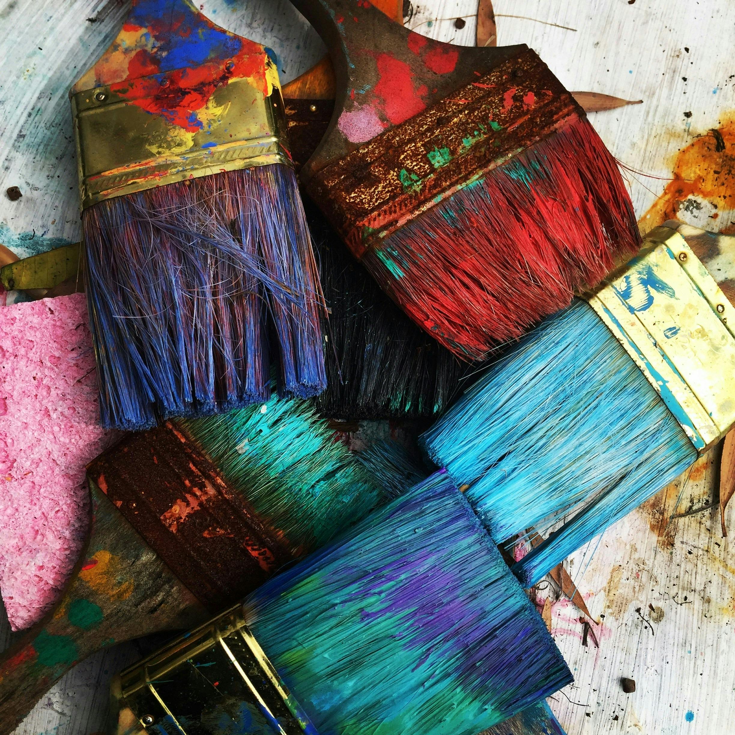 Photo of paint brushes with bright paint on the bristles
