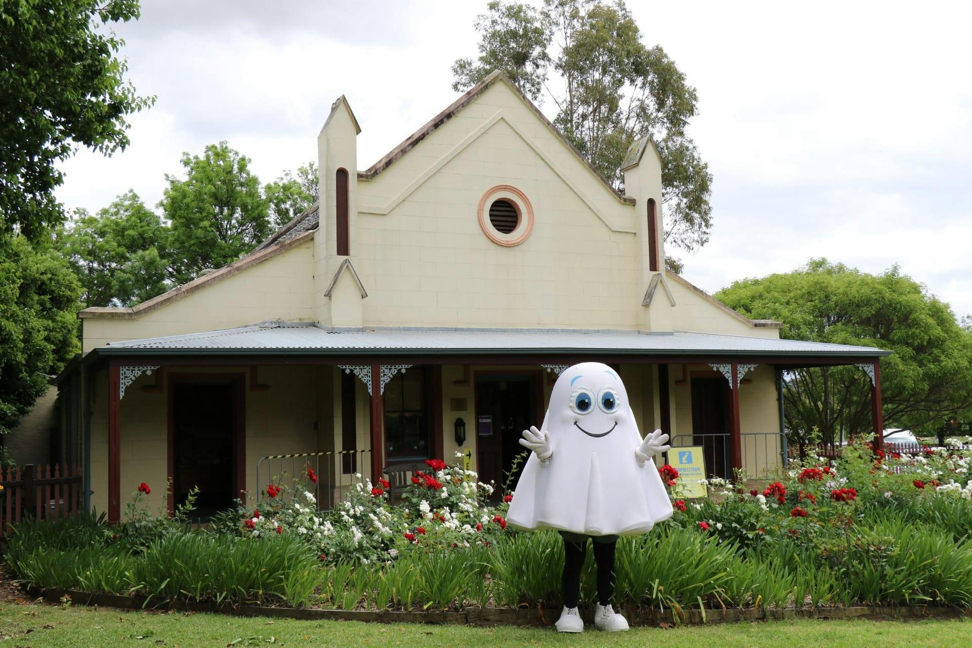 A person in a Ghost Costume in front of an old building