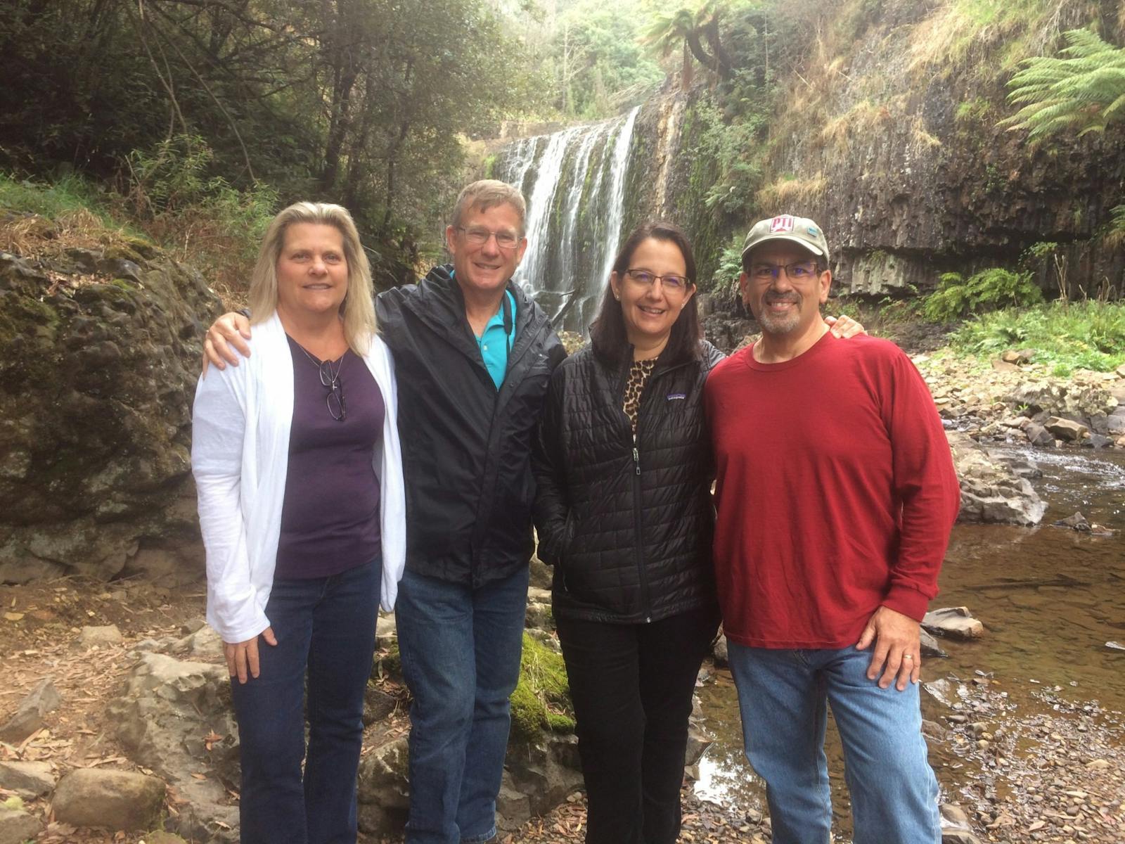 people standing near waterfall