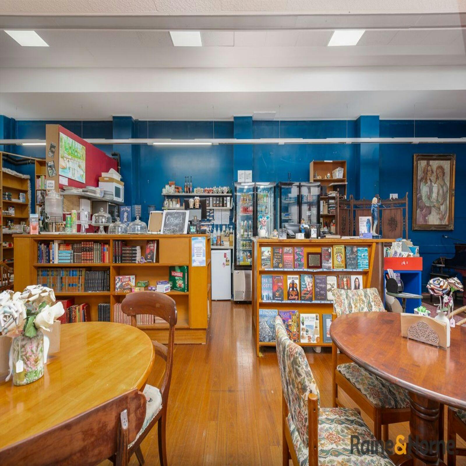 the front counter of the shop, blue wall, wooden furniture, many books