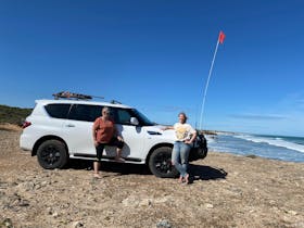 Passengers of tour outside vehicle with Canunda National park ocean views as a back drop.