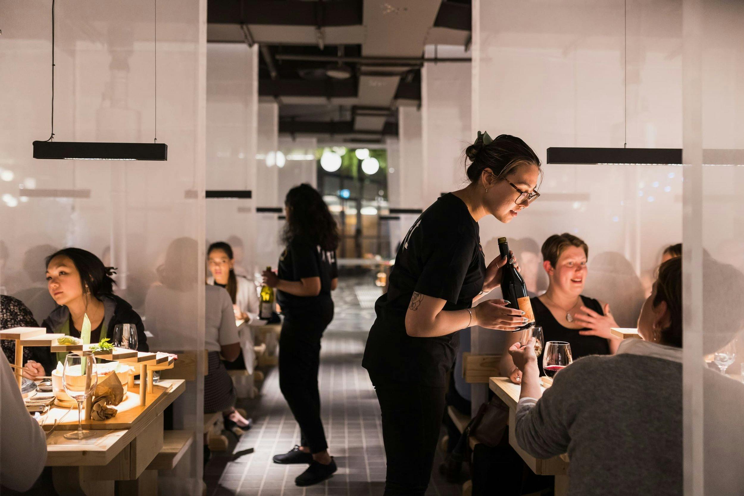 Service staff talking to patrons sitting at tables