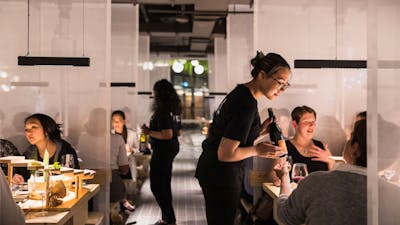 Service staff talking to patrons sitting at tables