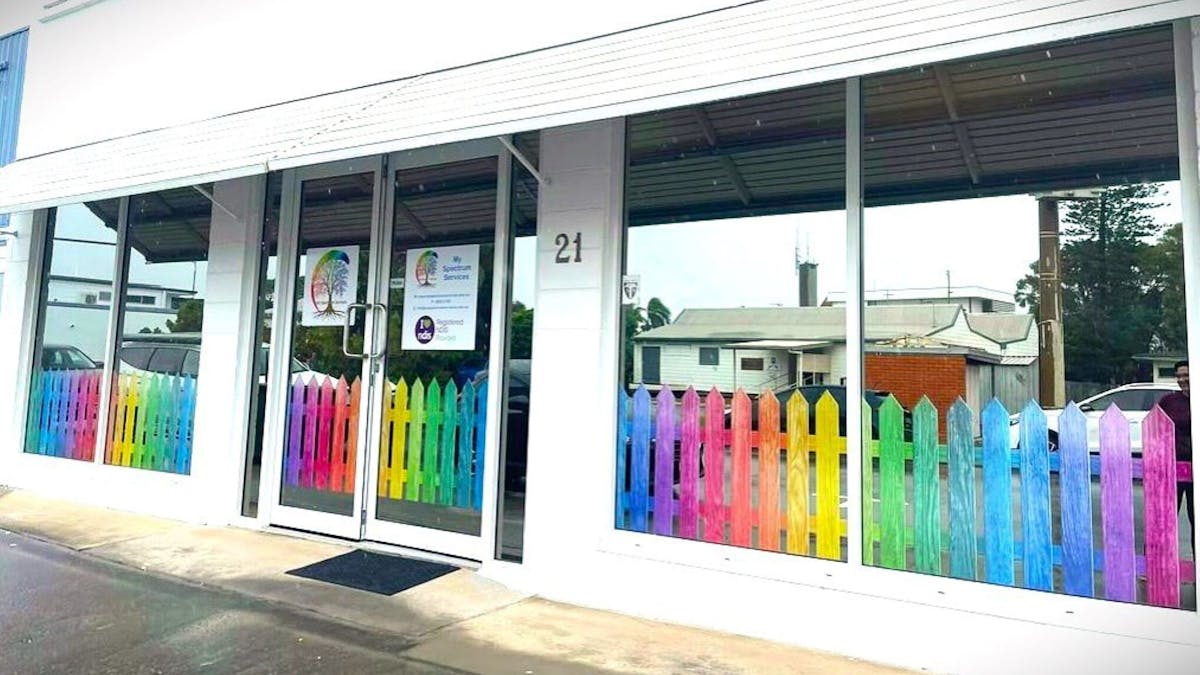 picture of front of building with rainbow fence and signage saying My Spectrum Services