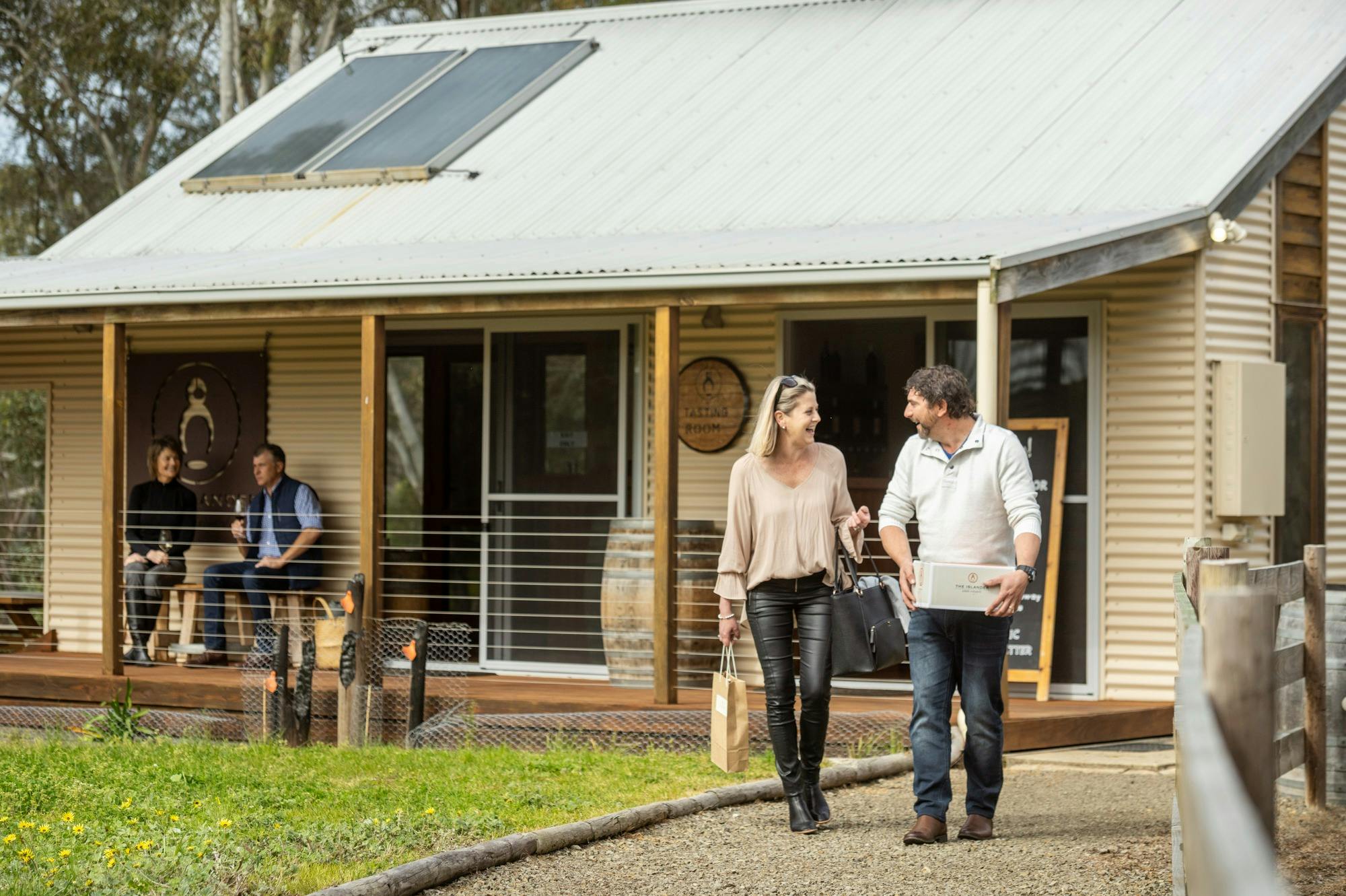 Couple leaving The Islander Estate Vineyards tasting room with wine
