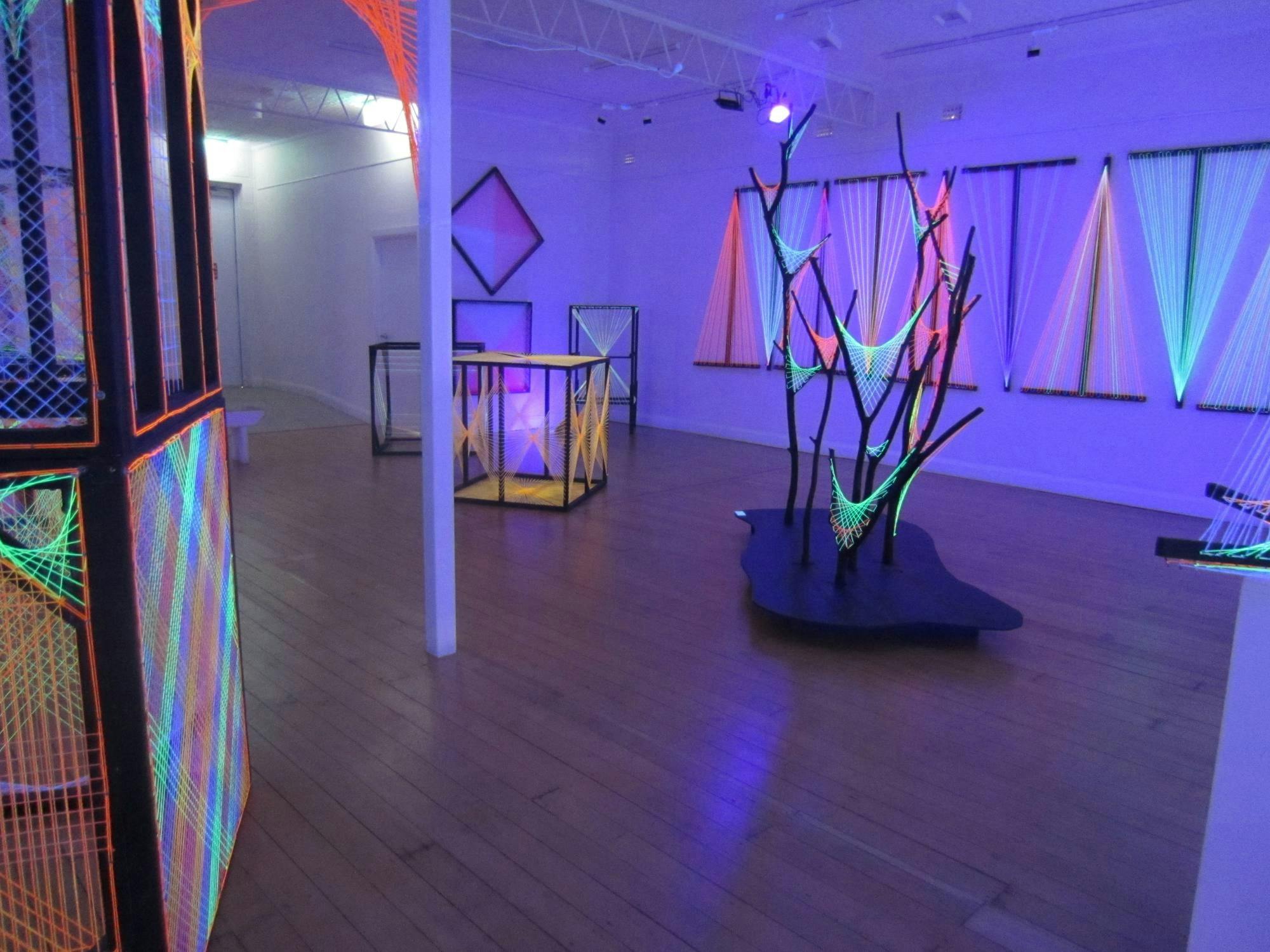 由绷紧在框架间的细绳构成的装置，在黑光灯下会发出霓虹灯光。