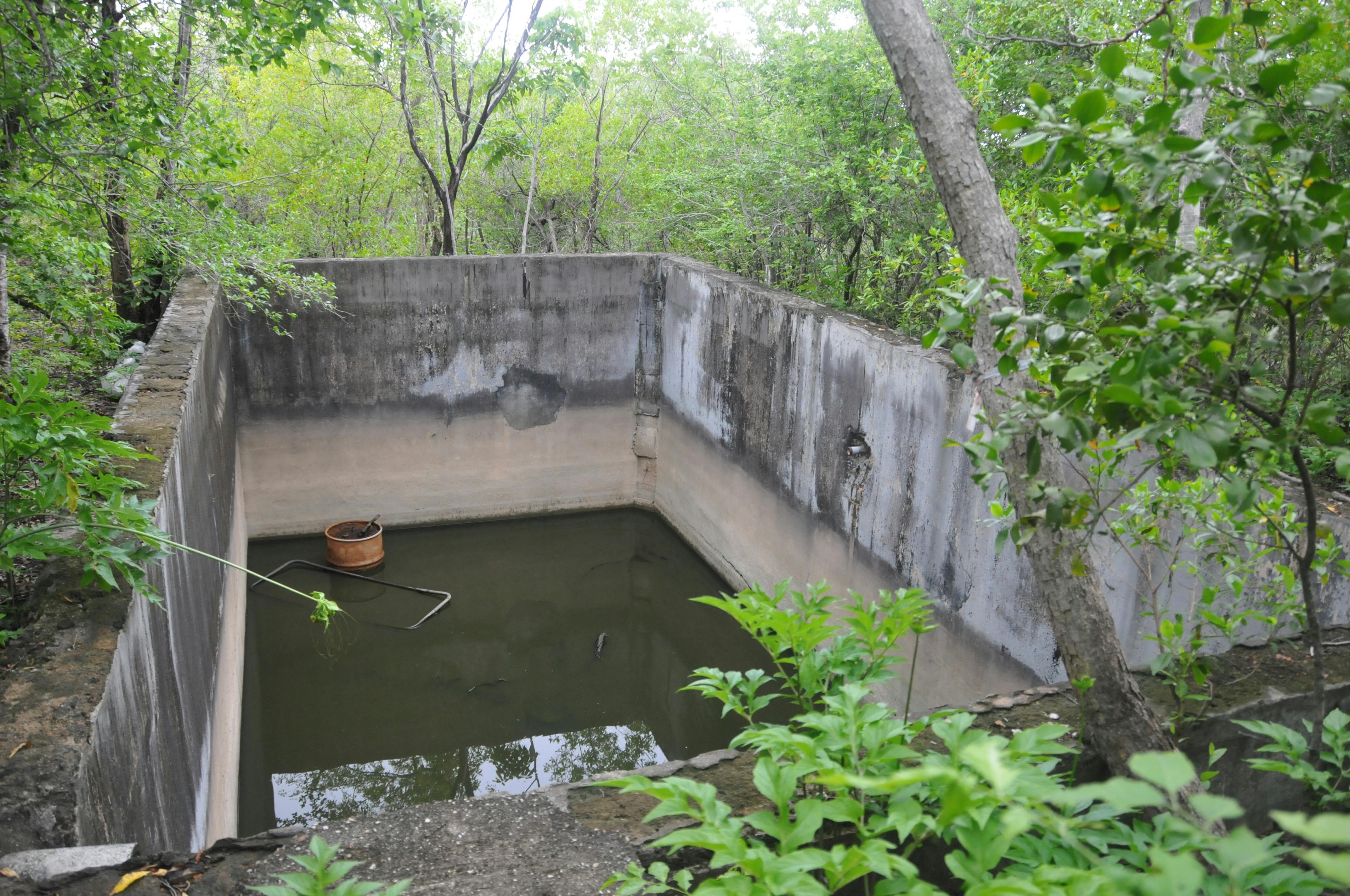 Concrete cistern. Adjacent are water tank slabs and remnants of a tank stand.