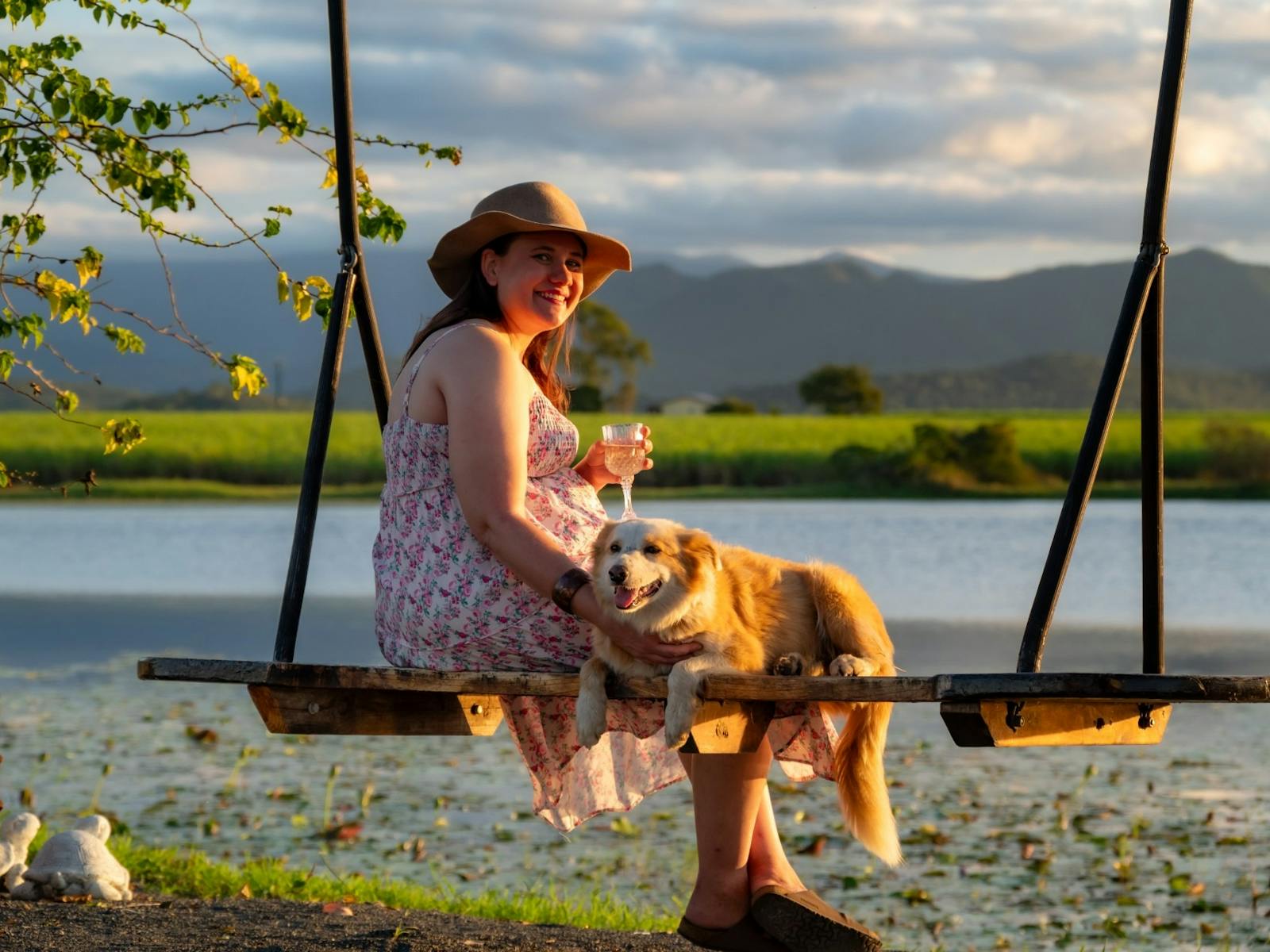 Lady sitting on the lo ve swing with her dog while drinking a glass of wine. Lady sitting on the lo ve swing with her dog while drinking a glass of wine.