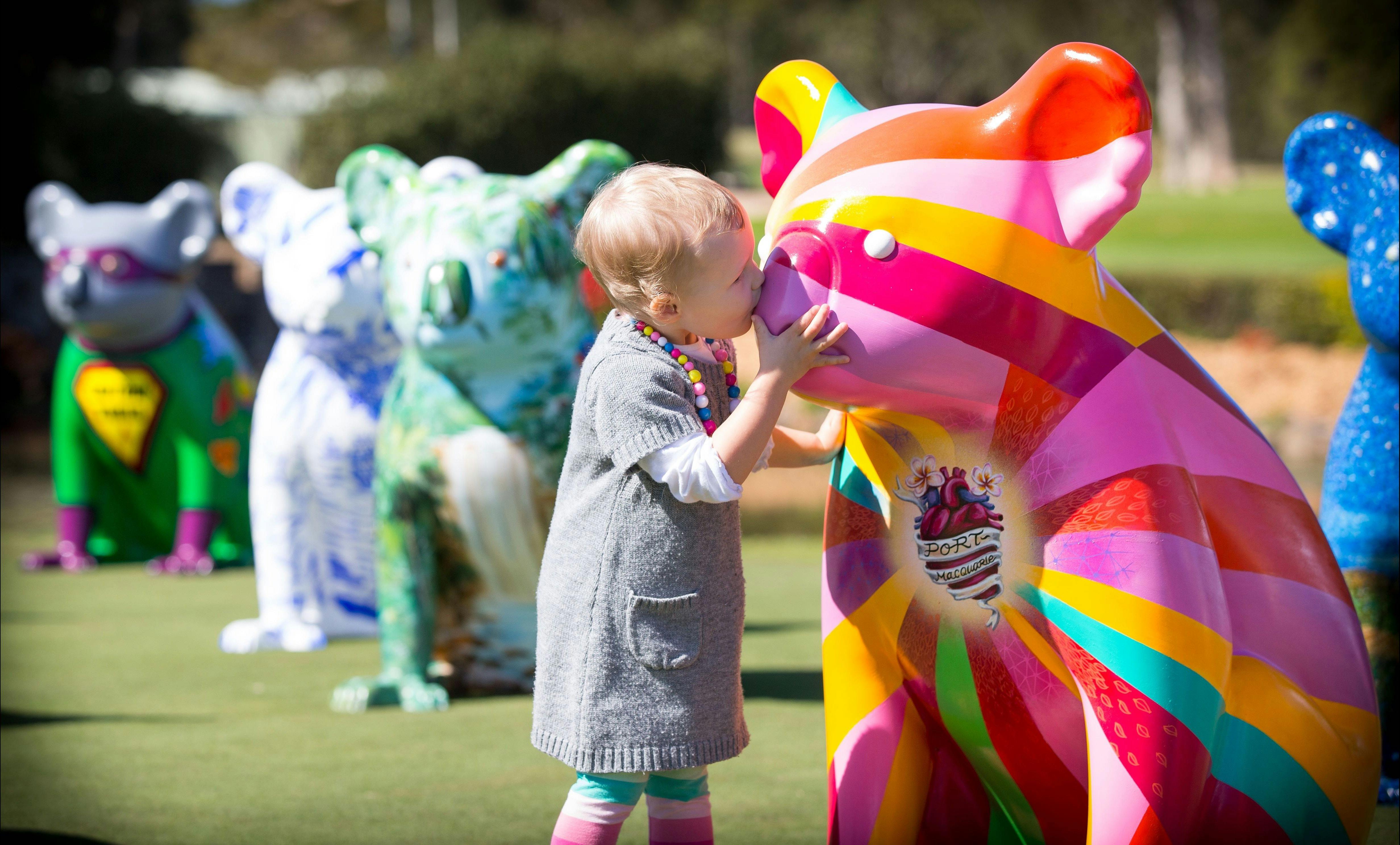 Jemma is kissing the Hello Koalas sculpture Radiant Heart on the nose