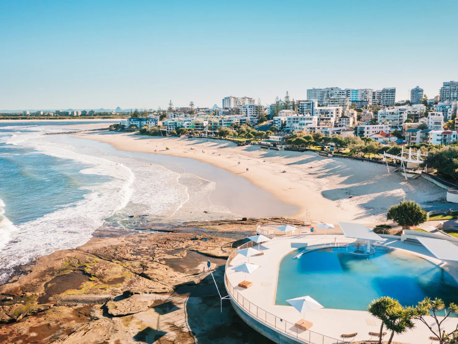 An aerial view of Kings Beach pool and beach landscape with buildings to the right