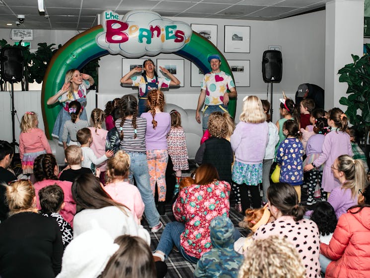 Beanies crew members performing in front of crowd of children