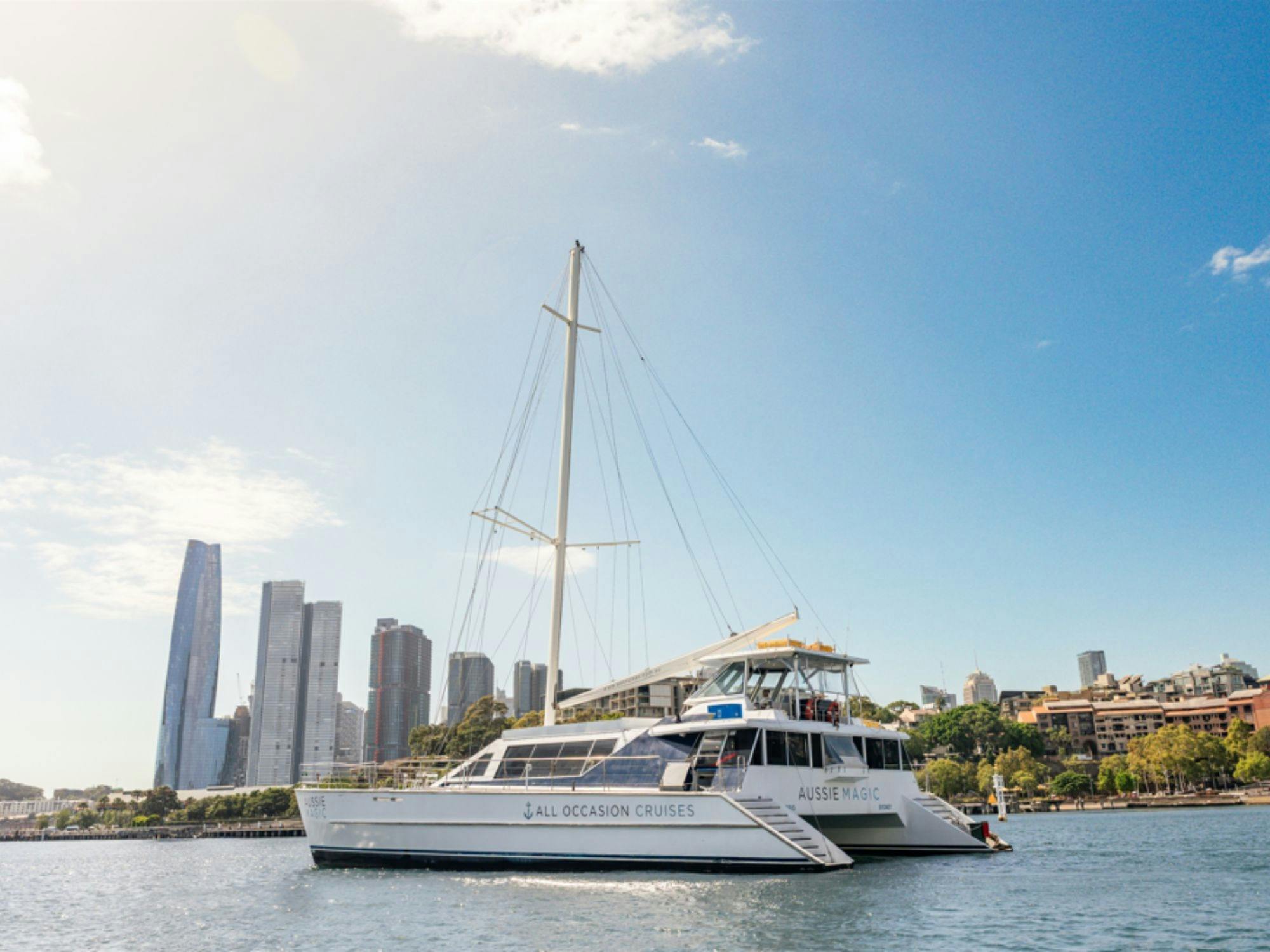 Aussie Magic catamaran on Sydney Harbour with the city skyline in the background