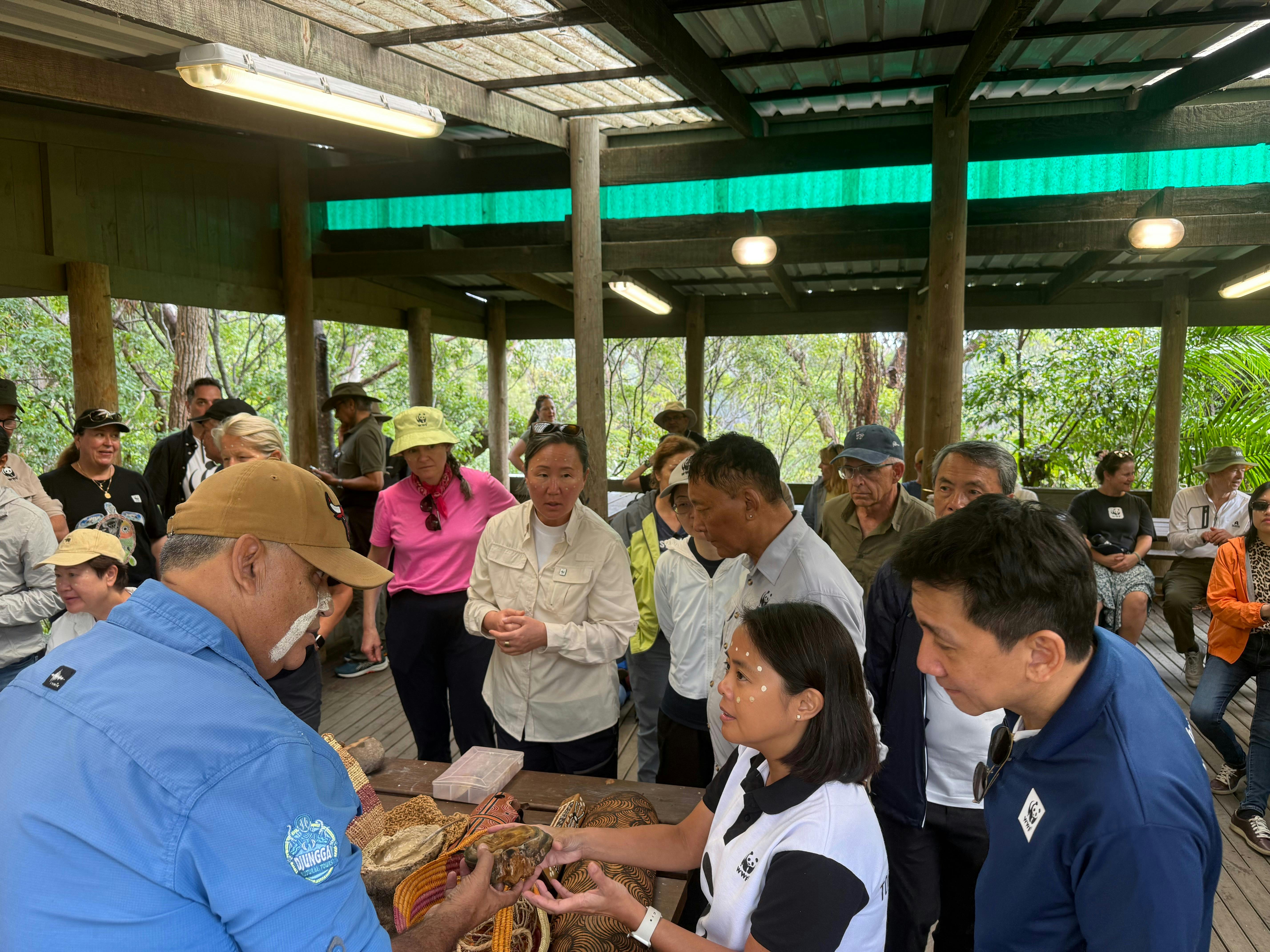 people in outdoor classroom with tools and artefacts and Aboriginal guide