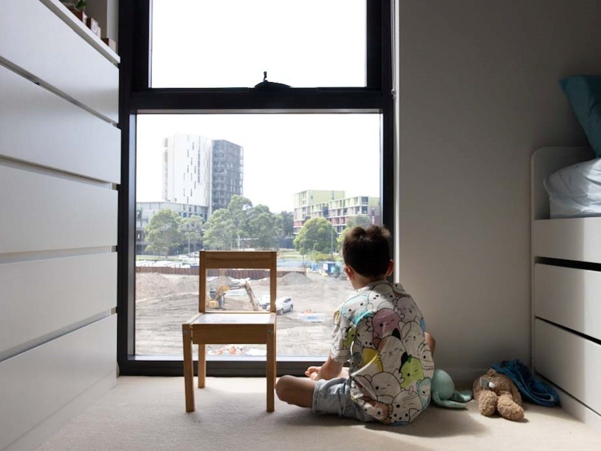 小孩在建築工地的公寓窗外張望