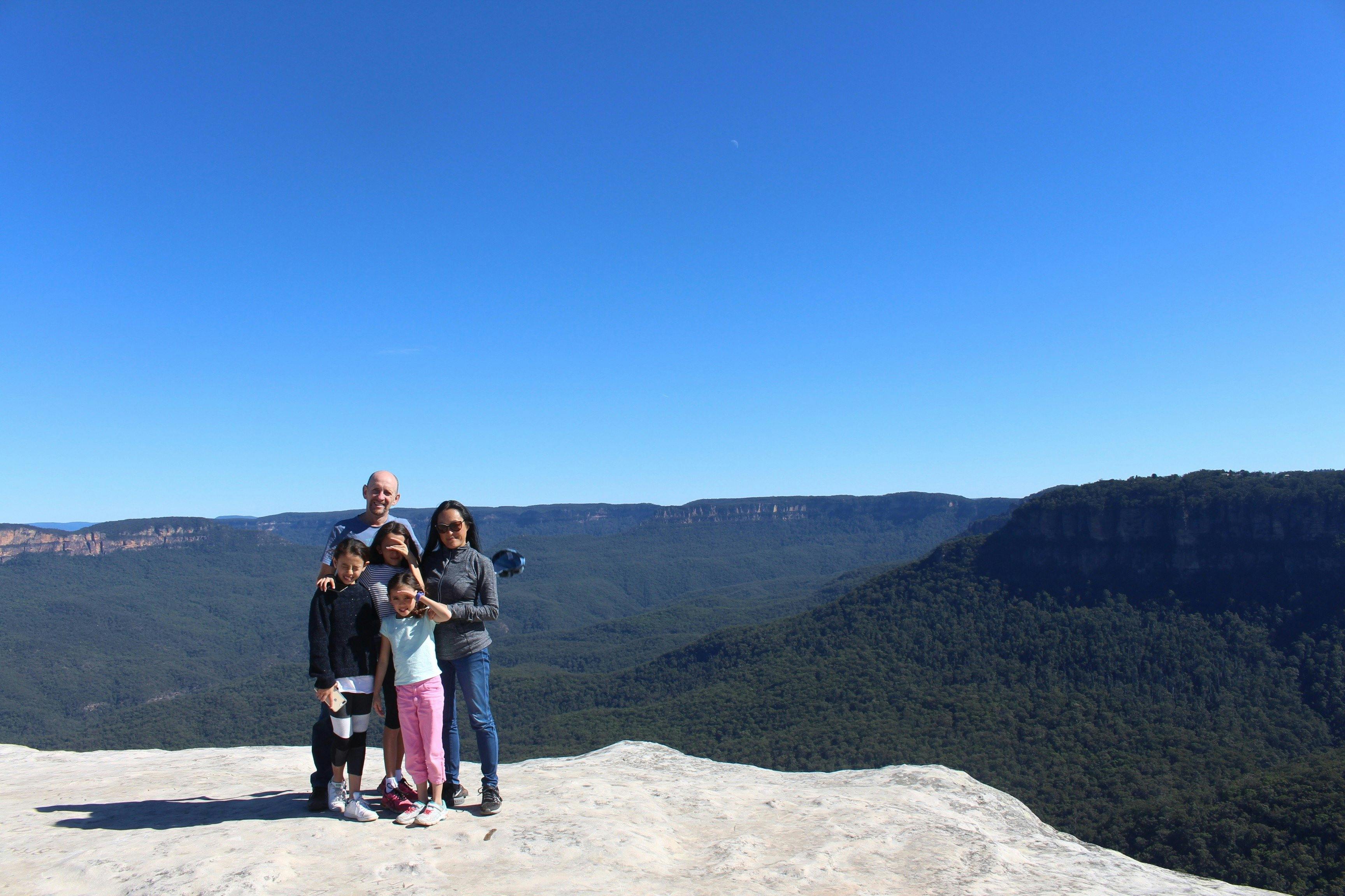 A family group posing at a lookout overlooking the Jamison valley