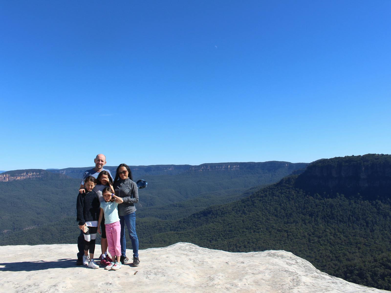 A family group posing at a lookout overlooking the Jamison valley