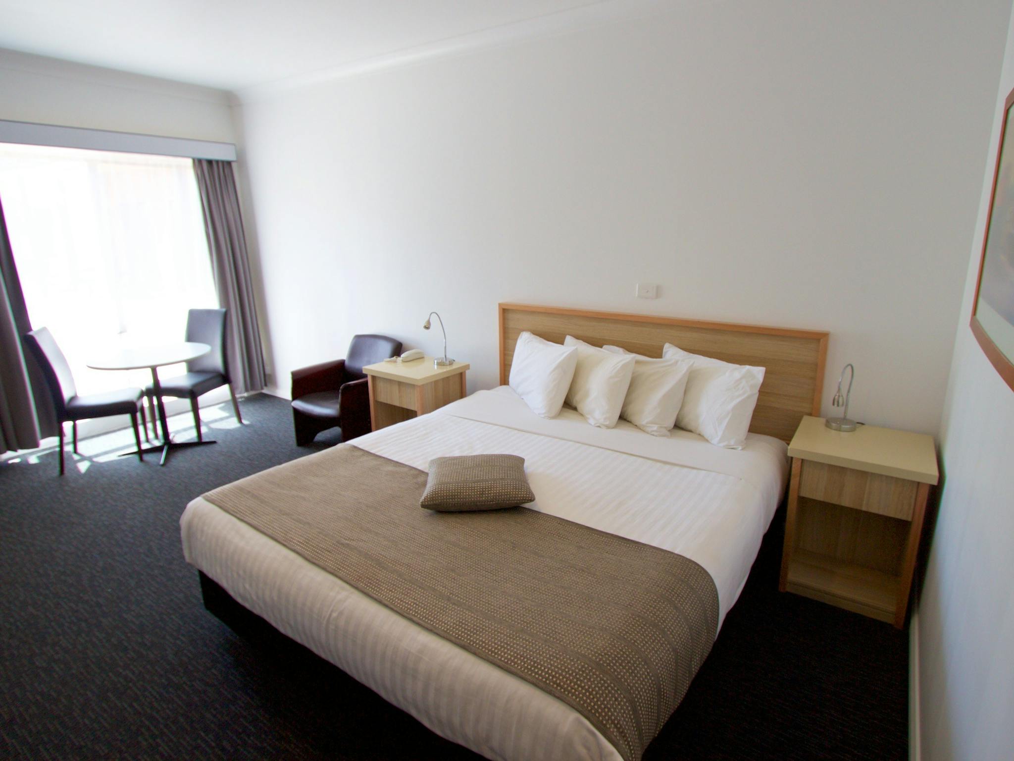 Guest room with large king bed on ground floor with separate sitting space