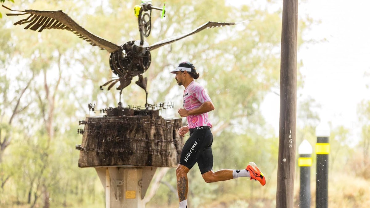 Runner in front of large sculpture on the banks of the MacIntrye river