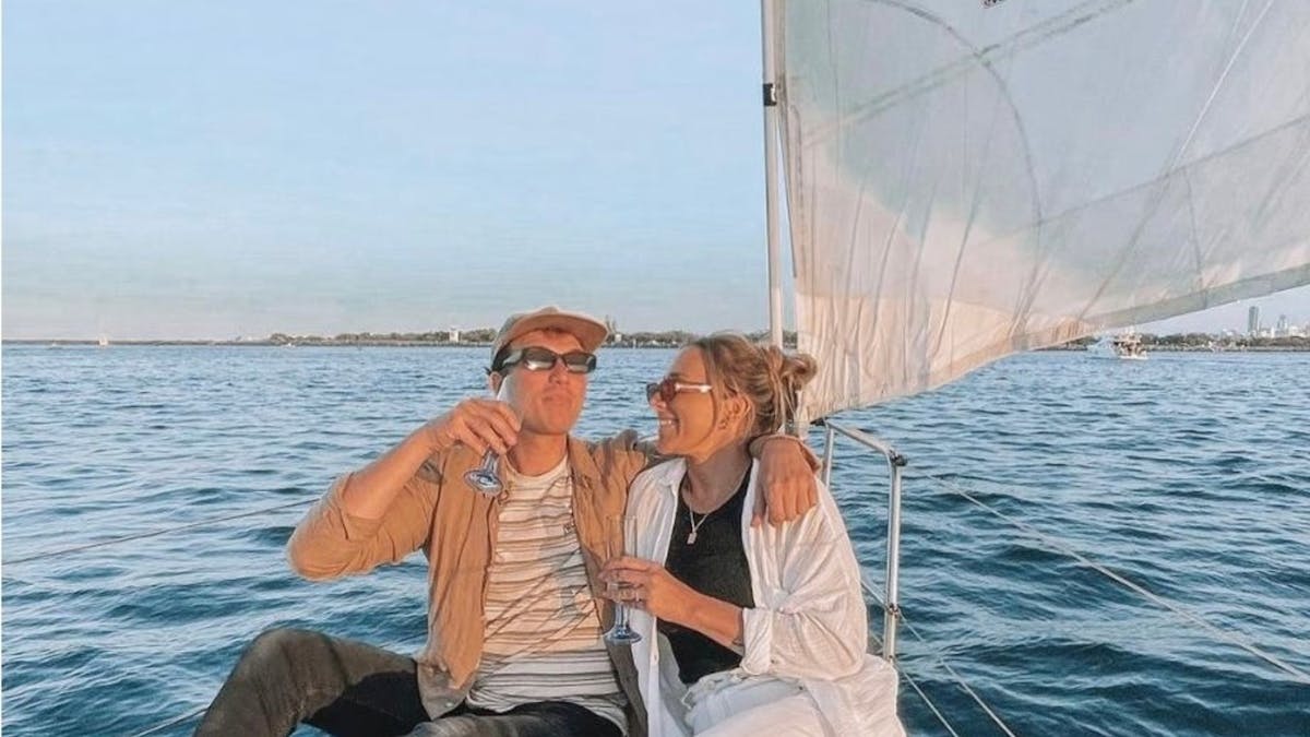 Romantic couple sailing aboard Sun Sailing's sunset private charter sipping sparkling wine.