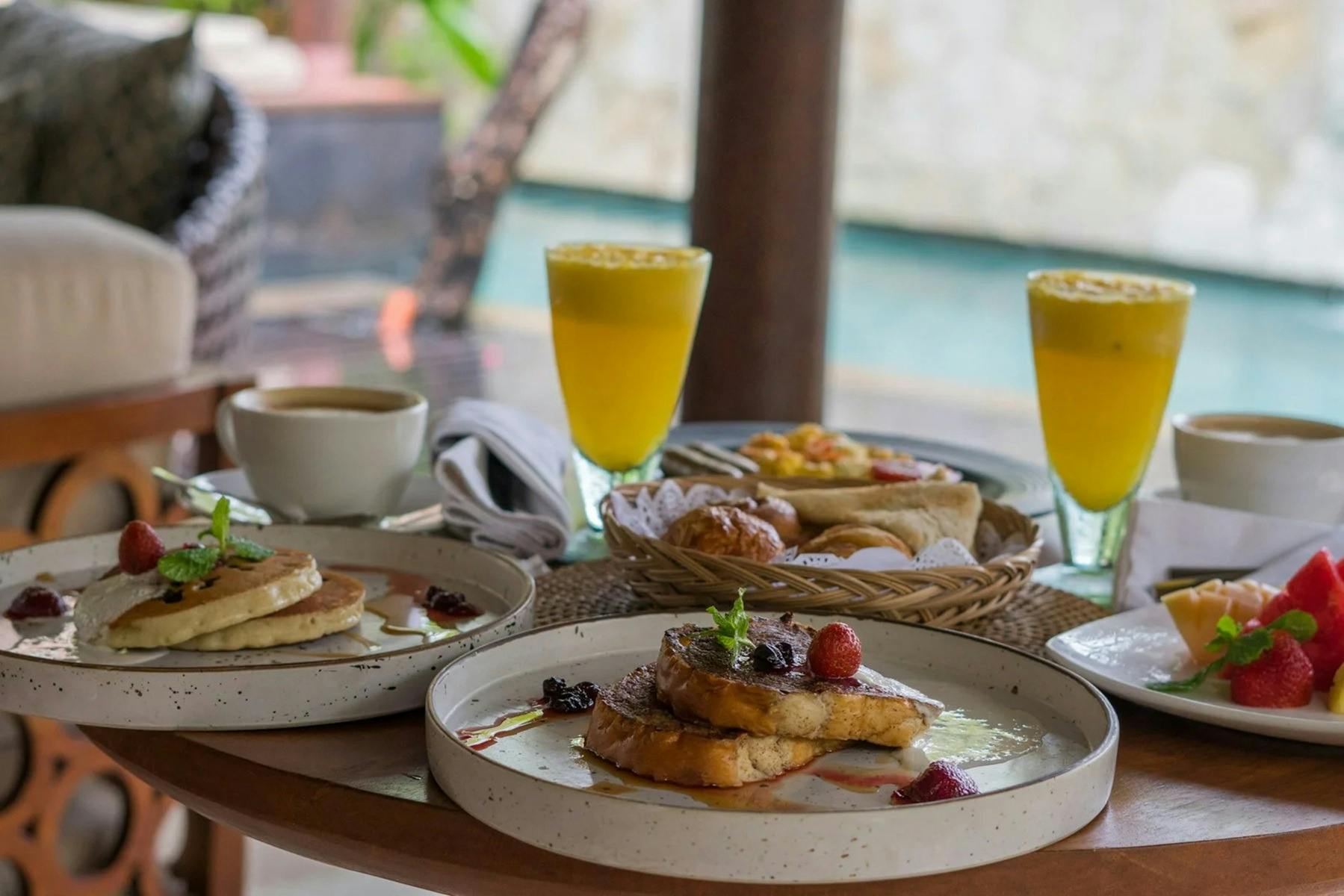 Break fast dishes on natural lit area with tall glasses of juice