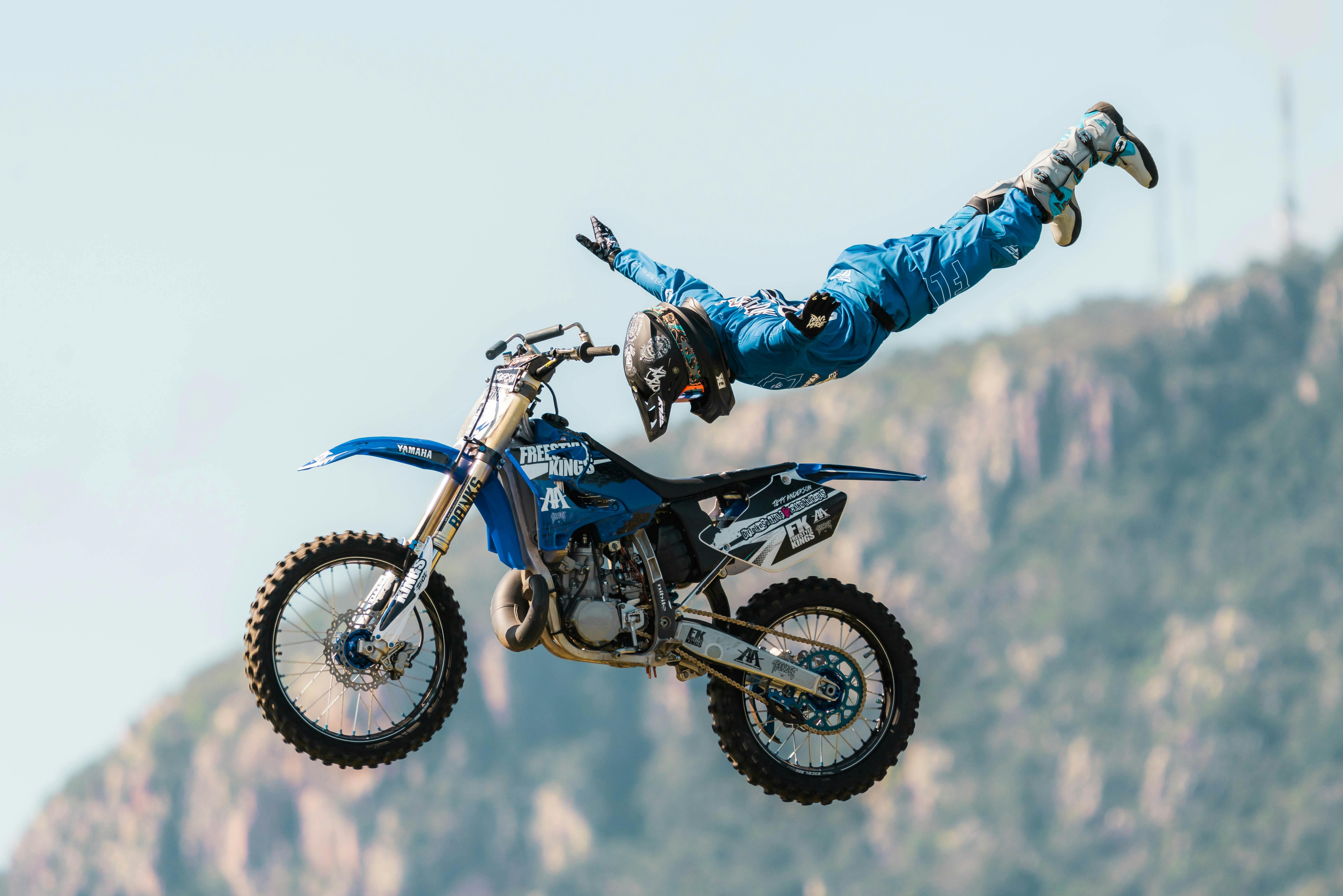 A motorcycle rider completes a trick while mid-air.