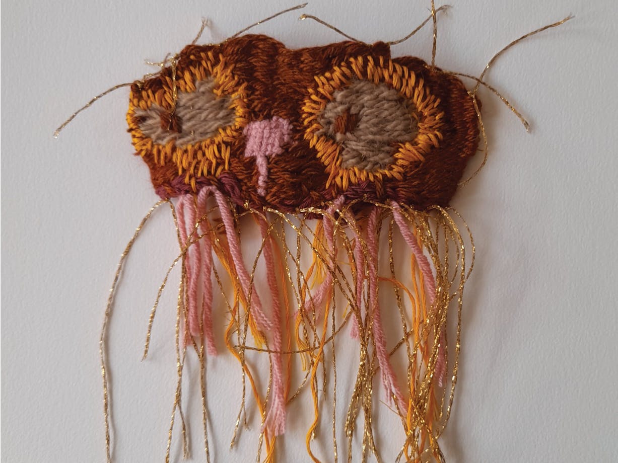 A textile wall hanging owl in shades of brown