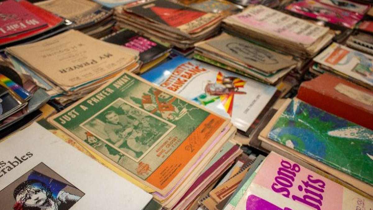 A table with sheet music laid out focus on nostalgic covers A table with sheet music laid out focus on nostalgic covers