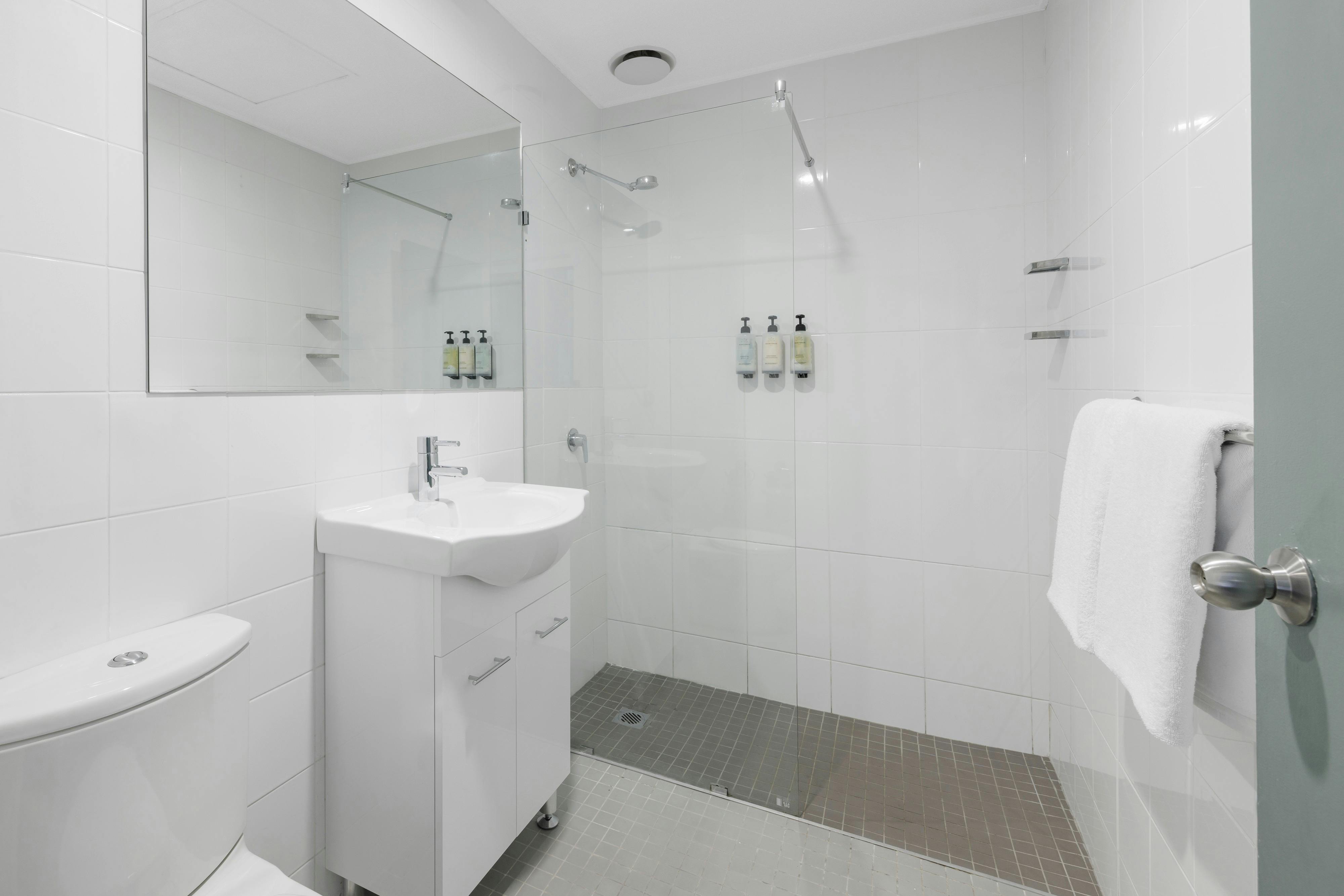 Modern private ensuite bathroom with shower, toilet, and vanity within the guest room.