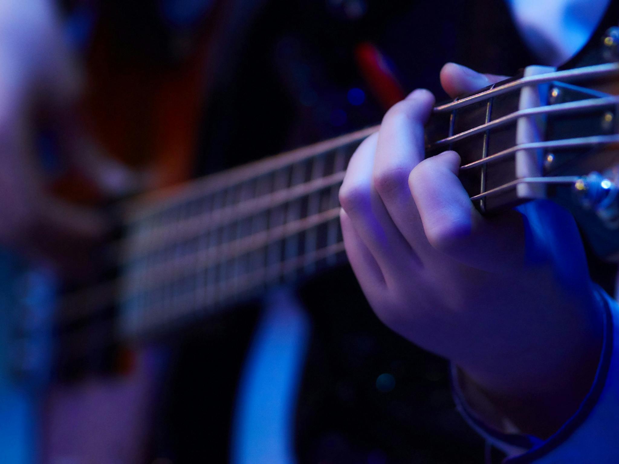 Close up image of a guitarist strumming his guitar