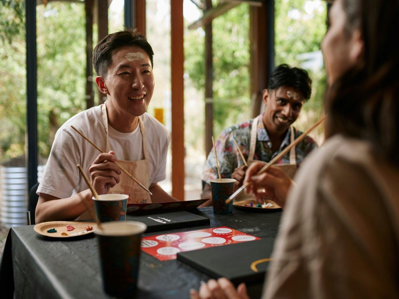 People painting in an Aboriginal art class