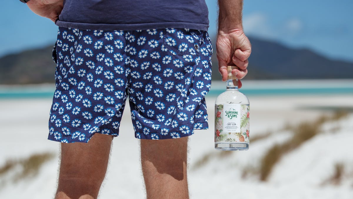 A man holding a bottle of Sunshine & Sons Original Dry Gin